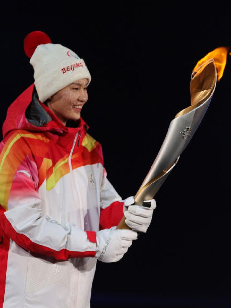 Two people carrying the Paralympic torch during the Opening Ceremony of the Beijing 2022 Paralympic Winter Games.